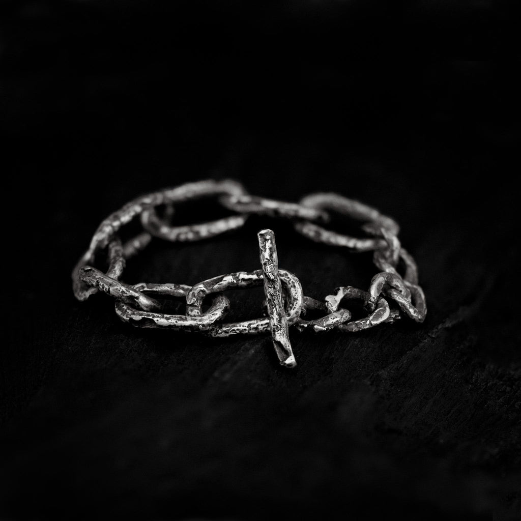 Sterling silver chain link bracelet with both round and cuban links on a dark background, made in Berlin.