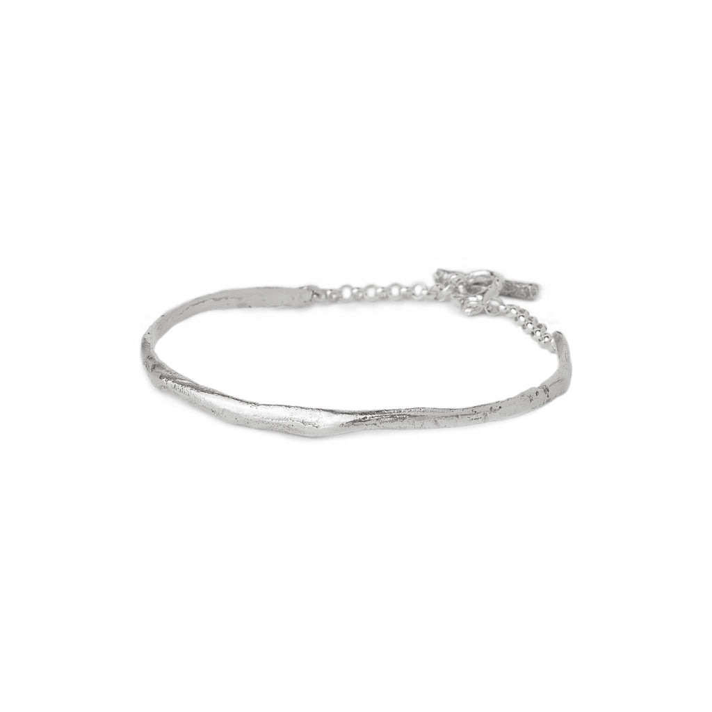 Silver cuff bracelet with an organic shape and lightly textured surface on a white background.