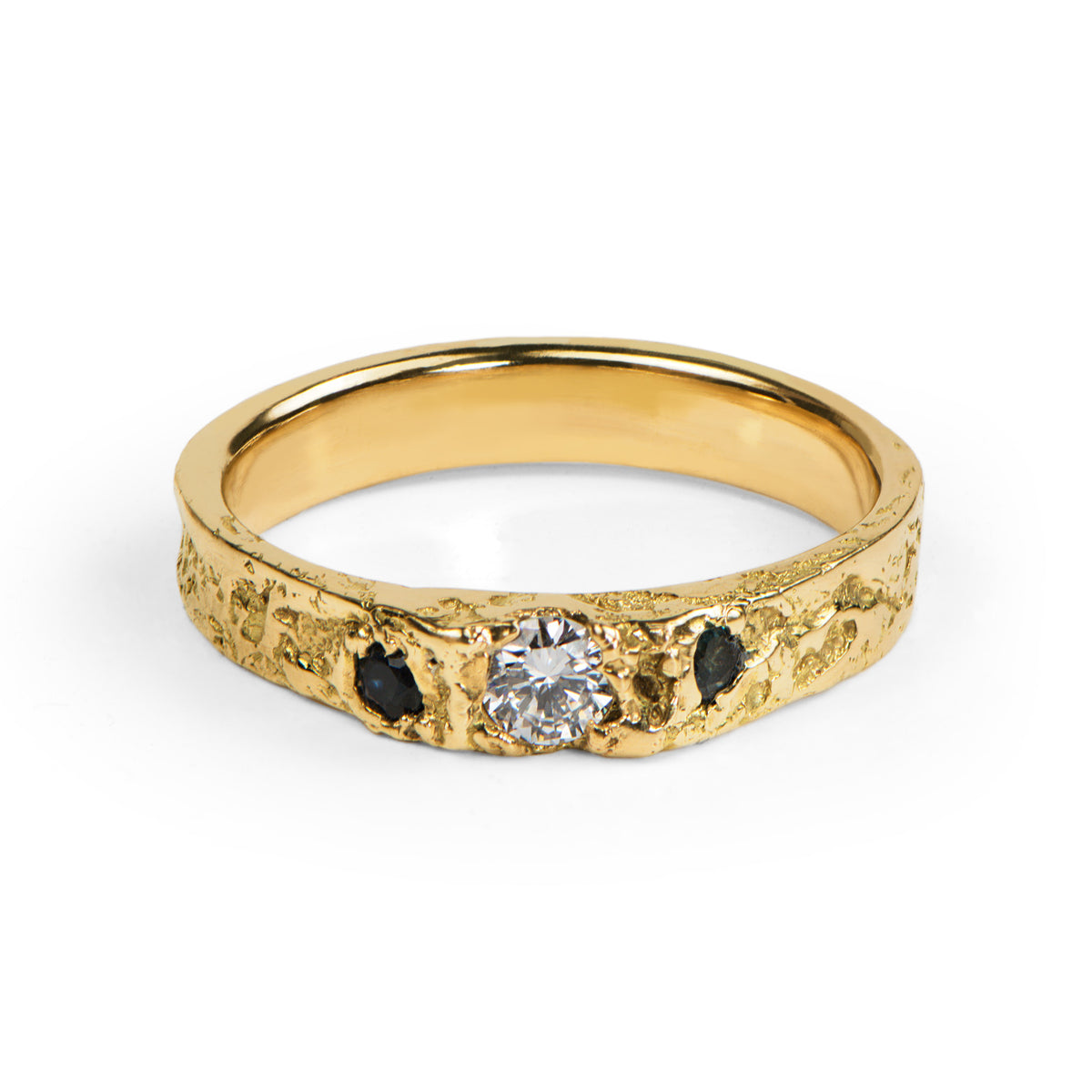 Handcrafted gold engagement ring with a central diamond and blue stones on a white background