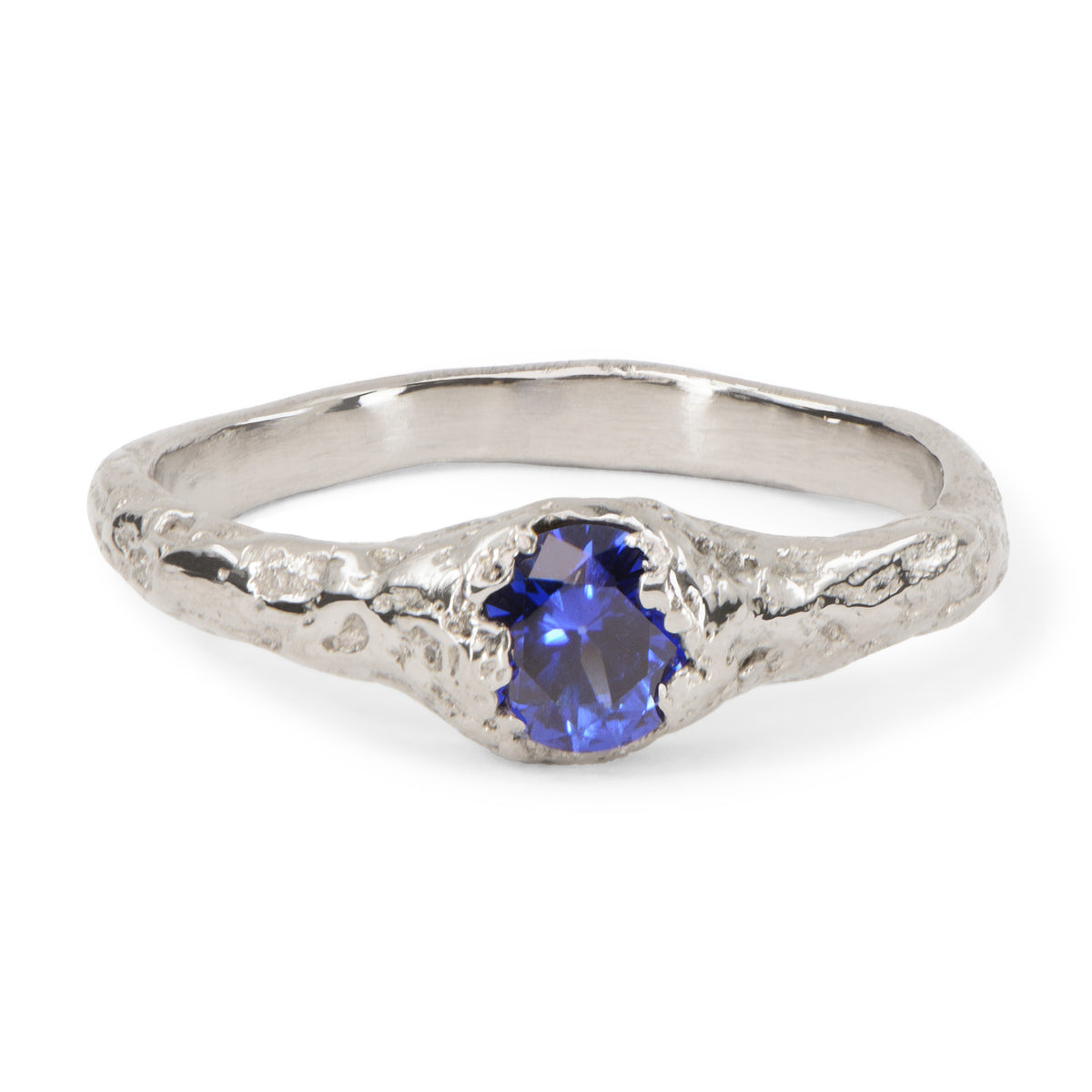Handcrafted organic white gold engagement ring set with a blue sapphire.