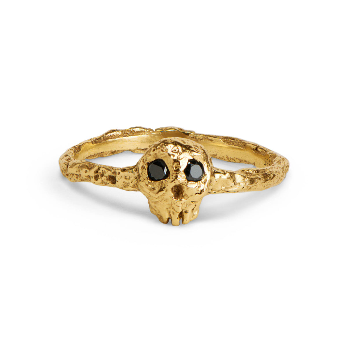 Gold skull ring with black gemstones on a white background