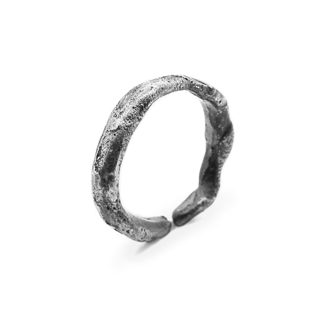 A single oxidised silver ring with a textured surface, showcasing a minimalistic design and adjustable size.