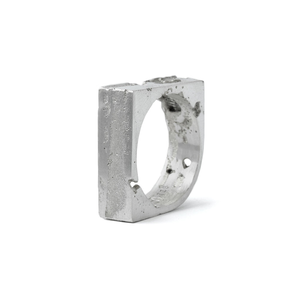 Handcrafted sterling silver ring with sculpted 8 mm wide band featuring textured and polished contrasts standing on a white background.