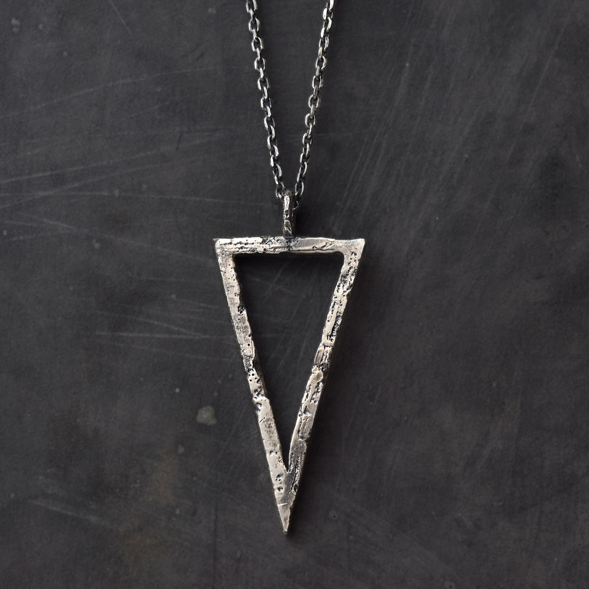 Handcrafted sterling silver triangle pendant necklace with an organic textured geometric design