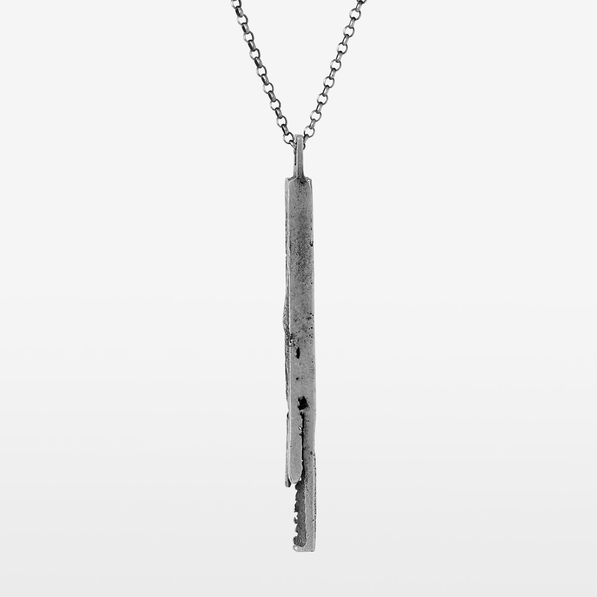 Handcrafted sterling silver bar pendant with a subtle vertical fissure suspended from a sterling silver chain on a white background.